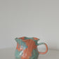 Orange ruffle rim ceramic mug with scalloped edge, front view